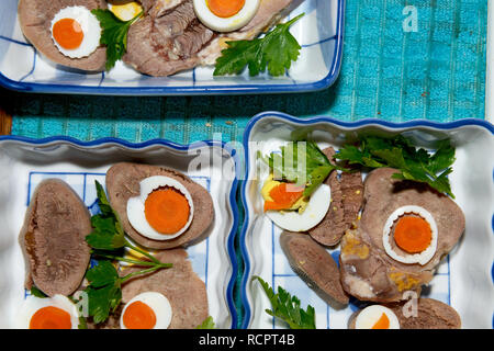 Close-up ingredienti per lingua in bellavista che sono disponendo in ceramica rettangolare piatti di insalata. Foto Stock