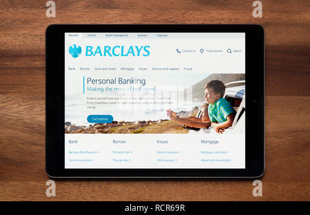 Il sito web di Barclays Bank è visto su un tablet iPad, il quale è appoggiato su un tavolo di legno (solo uso editoriale). Foto Stock