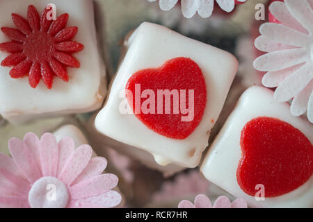 Colorato petit fours con decorazioni di fiori Foto Stock