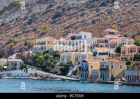 Seascape con vista panoramica delle tradizionali case colorate e la porta chiamato Yalos con le barche a vela in Symi isola Dodecaneso, Grecia. Foto Stock