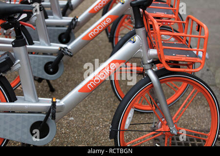 Londra, Inghilterra - Gennaio 15, 2019: Mobike dockless biciclette parcheggiate in una strada. Mobike è un bike sharing piattaforma per la breve distanza di viaggio. Foto Stock