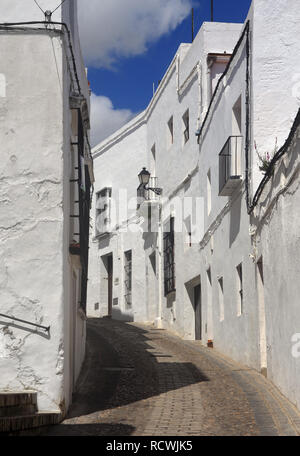 Tipica stretta, ripida strada nel centro storico di Arcos de la Frontera, Cadice, Andalusia, Spagna. Villaggio bianco rotta. Foto Stock