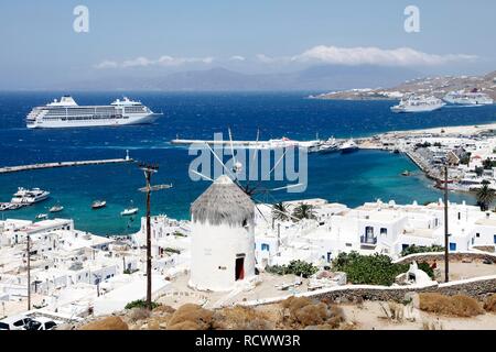 La vista della baia e il porto con i Boni Milos windmill, Mykonos, Mykonos, Grecia, Europa Foto Stock