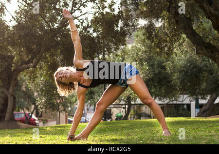 Bella donna fare yoga all'aperto nel parco. Foto Stock