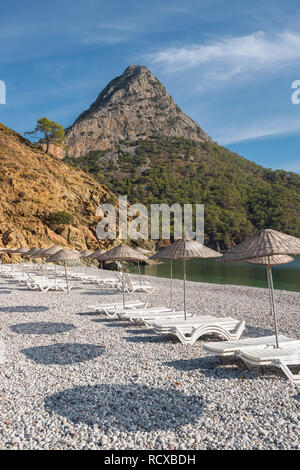 Ombrelloni e lettini sulla spiaggia di Adrasan a costa mediterranea in Turchia Foto Stock
