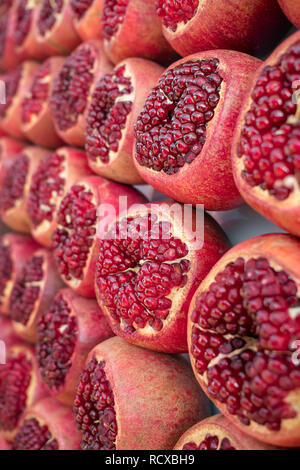 Mature e succose metà pelato melagrane pronta per essere spremuta di succo di frutta fresco. Vista ravvicinata Foto Stock