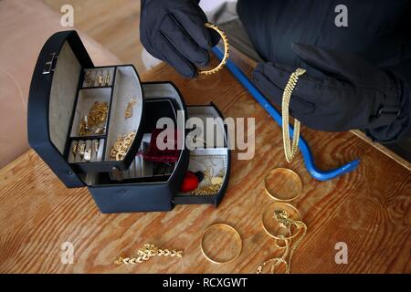 Ladro con una scatola di gioielli, immagine simbolica per i furti con scasso nelle abitazioni Foto Stock