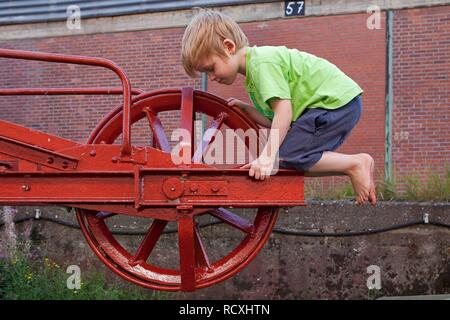 Little Boy giocando su una vecchia gru a Hafenmuseum, harbor museum, Amburgo Wilhelmsburg Foto Stock