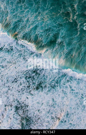 Una veduta aerea di una onda al tramonto sulla spiaggia di North Shore di Oahu. Foto Stock