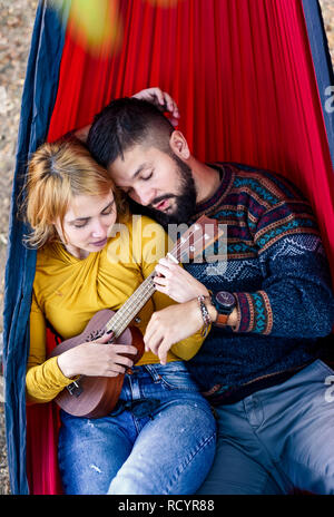 Amare giovane giacente in un'amaca su un picnic all'aperto Foto Stock