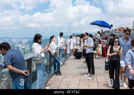 Visitatori sulla piattaforma di visualizzazione nella parte superiore della Victoria Peak, noto anche come il picco sull isola di Hong Kong che guarda la vista Foto Stock