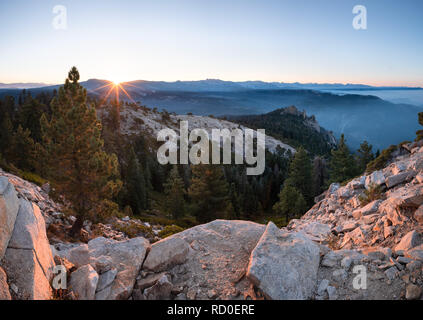 Sunrise e opacità del fumo sulla catena montuosa della Sierra Nevada e il camino Rock dal grande Baldy, Sequoia National Park, California, Stati Uniti Foto Stock