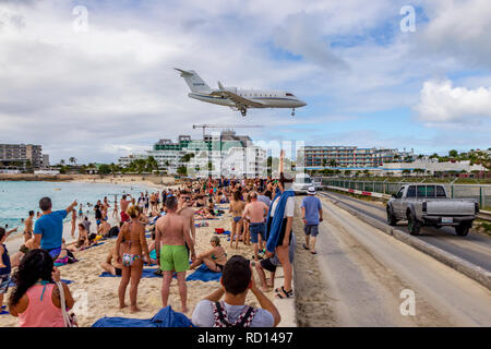 Bombardier CL-600-2B16 Challenger 604 battenti in basso sopra Moho bay in Princess Juliana airport in St martora. Foto Stock