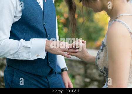 Sposa mette un anello sul govern dito Foto Stock