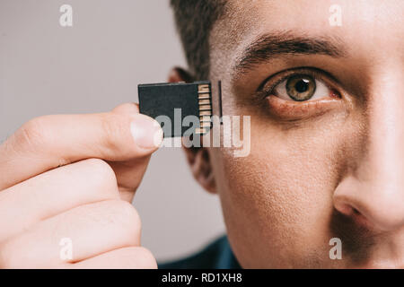 Messa a fuoco selettiva di uomo con microchip nei pressi di capo isolato su grigio Foto Stock