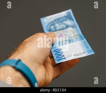 Parigi, Francia - 1 APR, 2018: uomo pagando con la carta moneta denaro 1000 Fiorino ungherese Foto Stock