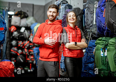 Ritratto di un uomo sorridente e la donna come venditori o i clienti nel negozio con attrezzature sportive Foto Stock