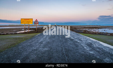 Segno: Singolo File traffico, Pericolo non procedere quando l'acqua raggiunge la Causeway, visto sulla strada tra Beal e Isola Santa in Northumberland, Inghilterra Foto Stock