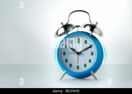 Orologio sveglia con segni di dollaro squilla con motion blur Foto Stock