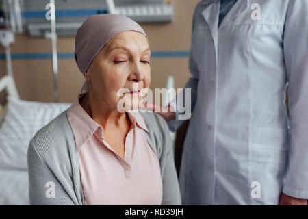 Messa a fuoco selettiva di dottore consolante senior donna con il cancro in ospedale Foto Stock