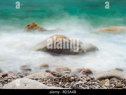 Immagini di rocce marine, prese con lunghi velocità otturatore, a sfumare le onde che li circondano Foto Stock
