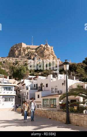 Giovane a piedi attraverso Alicante città vecchia con il castello in background, Spagna, Europa Foto Stock