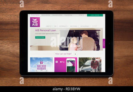 Il sito web di AIB (Allied Irish Banks) è visto su un tablet iPad, il quale è appoggiato su un tavolo di legno (solo uso editoriale). Foto Stock