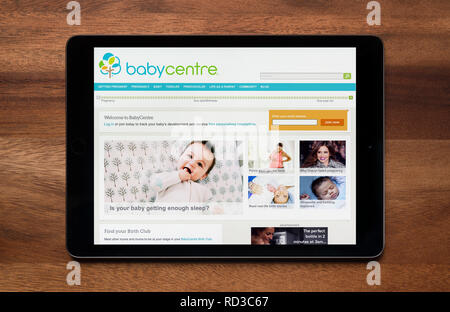 Il sito web del centro di bambino è visto su un tablet iPad, il quale è appoggiato su un tavolo di legno (solo uso editoriale). Foto Stock