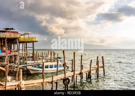 Panajachel, lago Atitlan, Guatemala - Novembre 12, 2018: ristoranti sul lago, pontili e imbarcazioni con vista torbida di Toliman e Atitlan vulcani dietro. Foto Stock