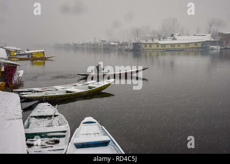 16 gennaio 2019 - Srinagar, Jammu e Kashmir India - Un barcaiolo del Kashmir righe la sua barca attraverso la Dal lago durante la fresca incantesimo di nevicata nel Srinagar.La regione del Kashmir è stato sperimentando neve per pochi giorni con conseguente interruzione del traffico aereo e il traffico stradale tra Srinagar e Jammu, estate e inverno capitelli del lato indiano del Kashmir. Credito: Idrees Abbas SOPA/images/ZUMA filo/Alamy Live News Foto Stock