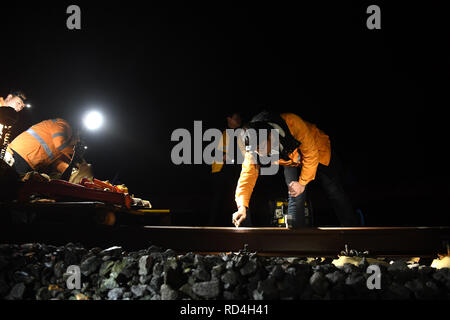 Huangshan, cinese della provincia di Anhui. Xvii gen, 2019. Lavoratori edili misurare il calibro al Huangshan Stazione Ferroviaria Nord sul Hangzhou-Huangshan ad alta velocità ferroviaria nella città di Huangshan, est cinese della provincia di Anhui, Gennaio 17, 2019. Lavoratori edili di Jixi nord sezione di fissaggio del China Railway Shanghai Group Co. Ltd, la maggior parte dei quali nati negli anni novanta e che hanno iniziato la loro attività prima della apertura ufficiale del Hangzhou-Huangshan rete ferroviaria ad alta velocità, sono responsabili per l'alta velocità di fissaggio binari presso la zona montuosa nel sud della provincia di Anhui. Credito: Liu Junxi/Xinhua/Alamy Live News Foto Stock