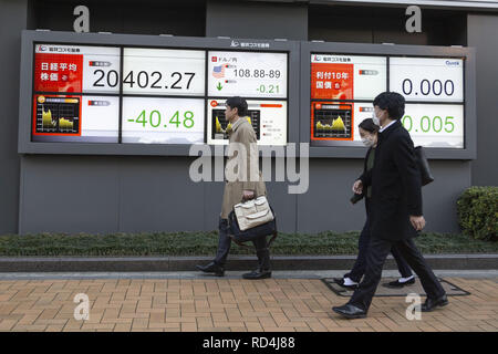 Gennaio 17, 2019 - Tokyo, Giappone - i pedoni a piedi passato un magazzino elettronico di bordo che mostra in Giappone il Nikkei Stock Media, che si è conclusa verso il basso 40.48 punti o 0,20 percento per chiudere a 20,402.27. Il più ampio indice Topix aggiunto 0,35% o 5,43 punti per riposare a 1,543.20. (Credito Immagine: © Rodrigo Reyes Marin/ZUMA filo) Foto Stock