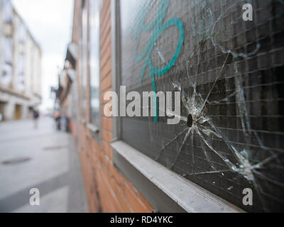 Bullet foro in una finestra con graffiti in un vicoletto Foto Stock