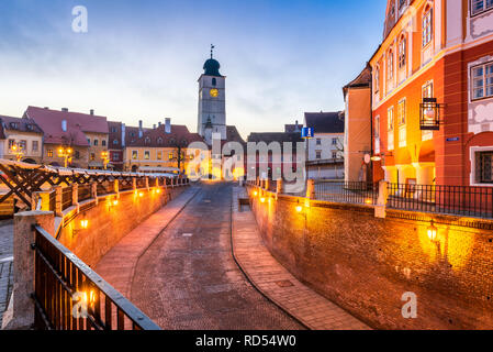 Sibiu, Romania - Lesser Square e Torre del Consiglio al crepuscolo. Transilvania città sassone. Foto Stock