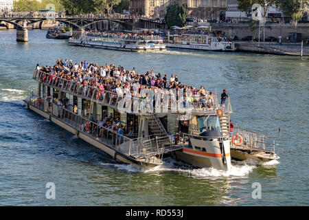 Le imbarcazioni turistiche imballato con i visitatori e i turisti di ammirare le attrazioni turistiche di Parigi dal fiume Senna .Paris Foto Stock