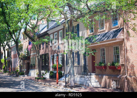 Fila di case a schiera in Philadelphia, PA, Stati Uniti d'America. La strada alberata è un esempio di struttura urbana tettoia. Foto Stock