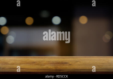 Vuoto in legno scuro tavolo di fronte abstract sfondo sfocato di ristorante, bar e coffee shop interno. può essere utilizzato per la visualizzazione o la vostra montage Foto Stock