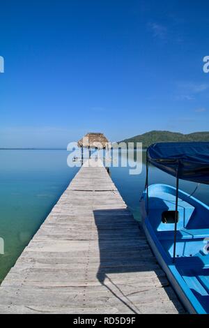 Lunga passerella di legno su un tranquillo lago Foto Stock