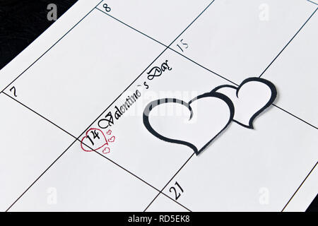 Pagina del calendario con il cuore il 14 febbraio, San Valentino su uno sfondo nero. Il giorno di San Valentino biglietto di auguri. Foto Stock