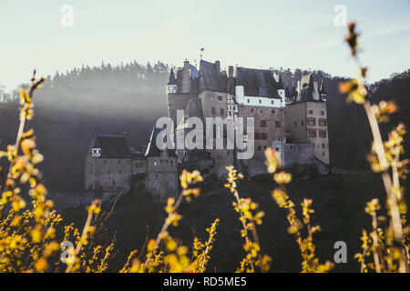Bellissima vista del famoso Castello Eltz in scenic golden. La luce del mattino al sorgere del sole in autunno, Wierschem, Renania-Palatinato, Germania Foto Stock