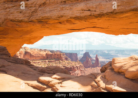 Visualizzazione classica del famoso Mesa Arch, simbolo del sud-ovest americano, illuminata a scenic golden. La luce del mattino al sorgere del sole su una bella giornata in estate Foto Stock