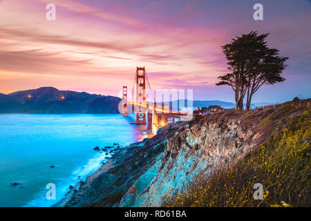 Classic vista panoramica del famoso Golden Gate Bridge visto da scenic Baker Beach in splendida post tramonto tramonto con cielo blu e nuvole al tramonto Foto Stock