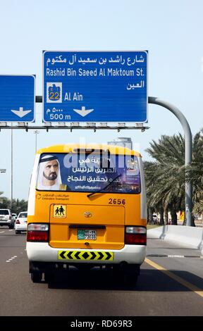 Scuola bus visualizzando la foto di Muhammad Bin Rashid Al Maktoum, il righello dell'Emirato di Dubai, bus guida su un Foto Stock