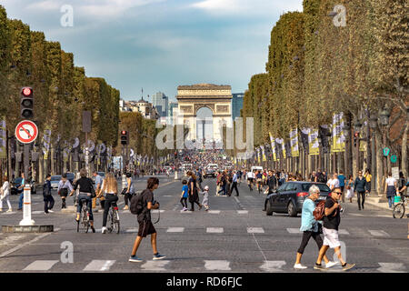 Attesa del traffico in corrispondenza di un segnale vicino a Place de la Concorde sulla Champs-Élysées con l'Arc de Triomphe in distanza , paris , France Foto Stock