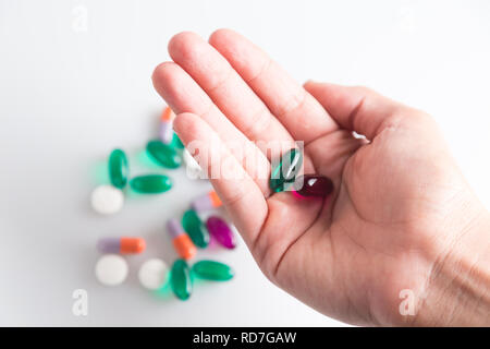 Una persona in possesso di due pillole al di sopra del resto dei medicinali Foto Stock