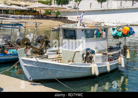 Sovraccarico bianco pesca barca ancorata accanto al dock in città. Foto Stock