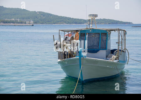 Di piccole dimensioni e di colore bianco sovraccaricato la pesca in barca ancorata accanto al dock. Foto Stock