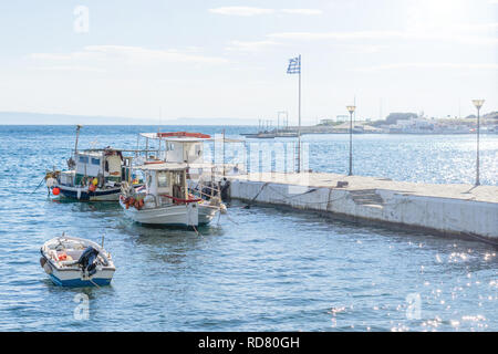 Di piccole dimensioni e di colore bianco sovraccaricato di barche da pesca ancorata accanto al dock. Foto Stock