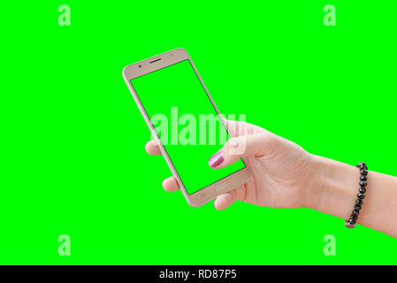 Il telefono in mano ragazza, close-up. Isolato in verde, il chroma key. Foto Stock