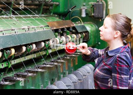 Altamente esperti donna svedese utilizzando restaurato di lana e macchine tessili dal XIX secolo per eseguire una linea di produzione di prodotti in maniera sostenibile la lana e prodotti tessili . Foto Stock